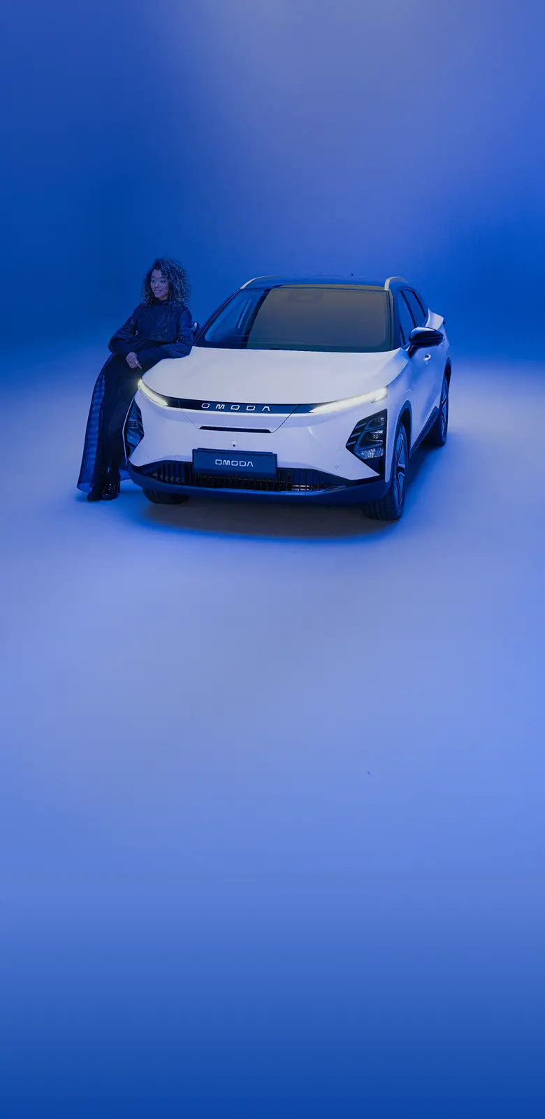 Women dressed in black clothing posed against a white OMODA